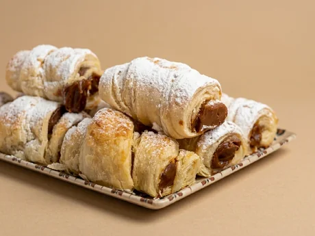 Bollos de hojaldre rellenos de dulce de leche espolvoreados con azúcar glas