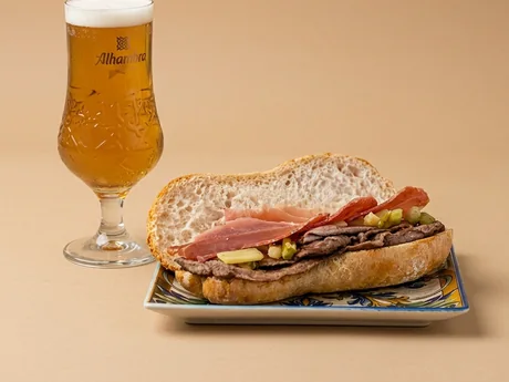 Bocadillo grande de lomo y jamón con una cerveza