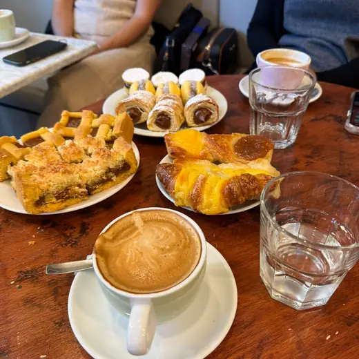 Mesa de desayuno con café, bollería y empanadas