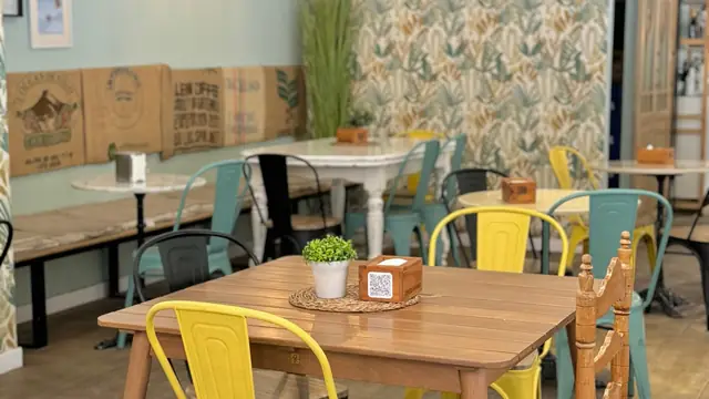 Interior de La Cuadra con mesas de madera y sillas amarillas